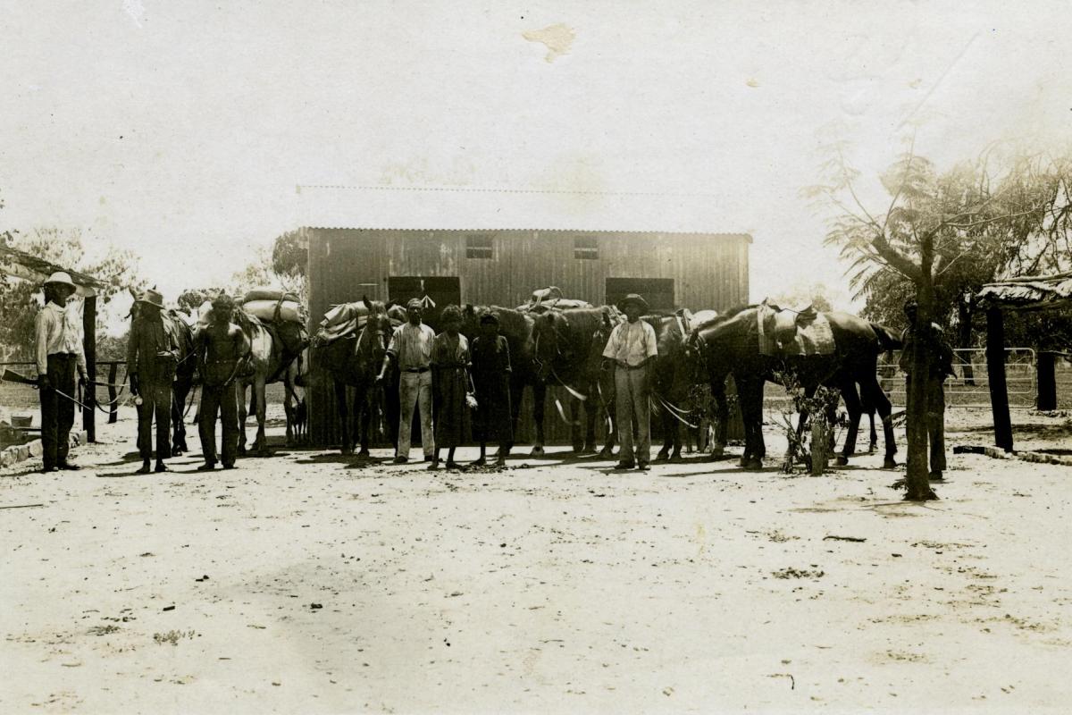 Lock-up at Police Station, Leichhardt's Bar, NT. Mounted Constable John Robert Johns is on the left. The third person from the left is Neighbour. He is a prisoner in chains which are held by the man second from the left.