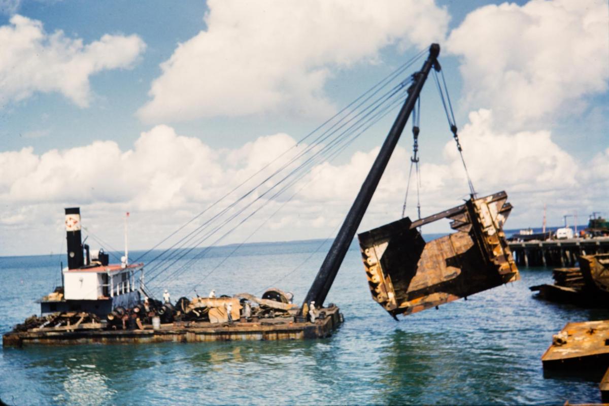 A floating barge crane raises salvage material from Darwin Harbour.