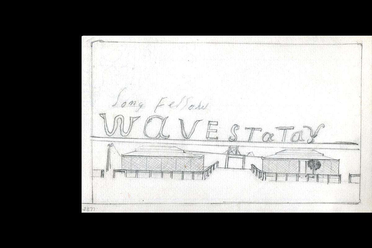 Two low buildings surrounded by a fence stand either side of a small tower.