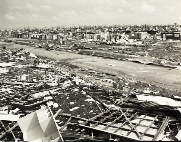 Street level view of house debris and a flattened city