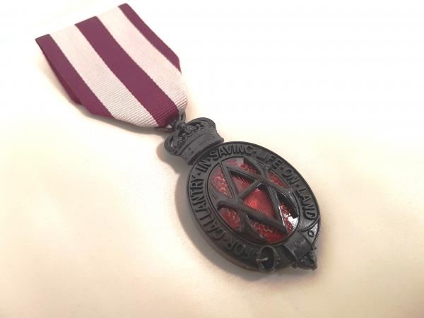 Replica of Ayaiga’s Medal, 2018. © Michael Barritt Photographer. Used with Permission Albert medal. Ribbon is striped maroon and white. Medal is made of bronze with red embelishments