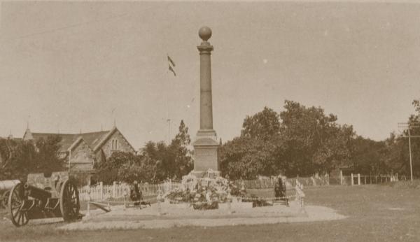 Cenotaph, c. 1930 Library & Archives NT, S.S. Godfrey Collection, PH0650/0133 The Cenotaph stands at centre with floral wreaths at its base. In the background is Government House and two machine guns. At left is a field gun.