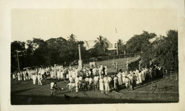 Cenotaph War Memorial, c. 1936. Library & Archives NT, Marella Collection, PH0375/0096 A large crowd of men and women surround the Cenotaph at centre. At far right is a line of troops, the Darwin Garrison. In the background is Government House and a flagpole with flag. In the foreground at right is a pushbike.